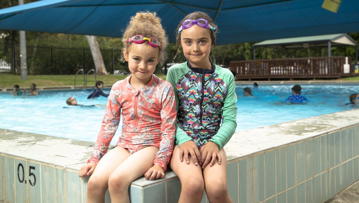 Georgia Rowley, 5, and Stella Rowley, 7, having their first swim at Dickson Pool. Picture: Keegan Carroll