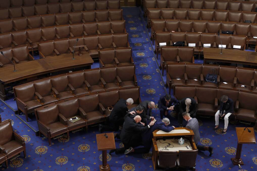 Members pray together on the floor of the House of Representatives. Picture Getty Images