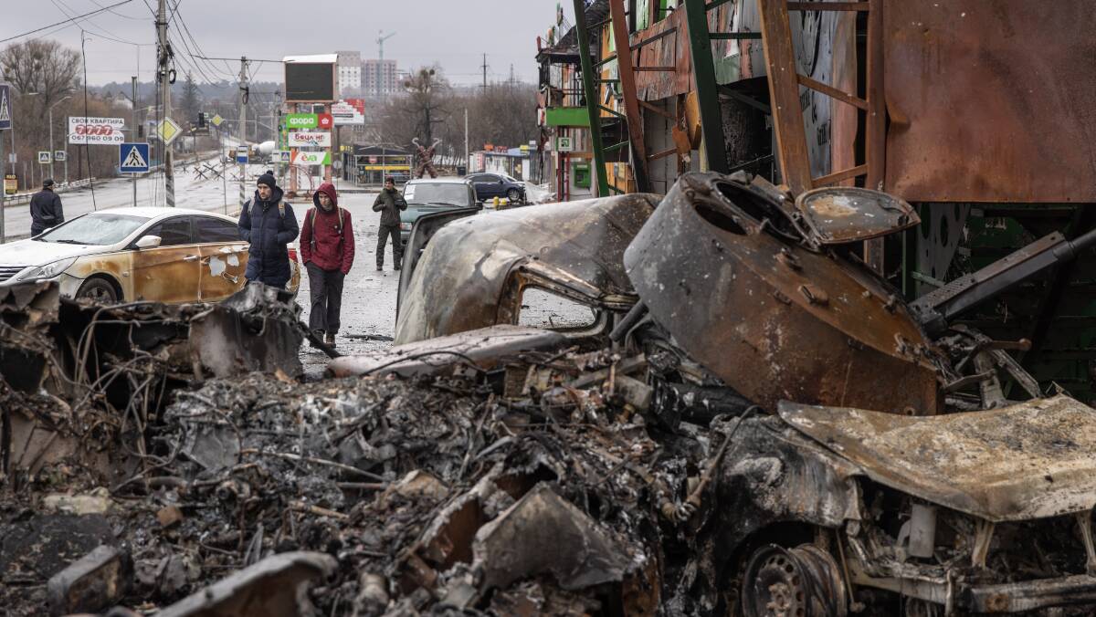 People walk past a destroyed Russian military vehicle near Kyiv. Picture: Getty Images