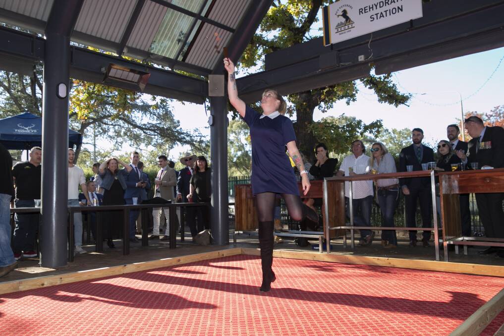 Angela Cooper plays two-up at the Olims Bar in Reid on ANZAC Day. Picture: Keegan Carroll