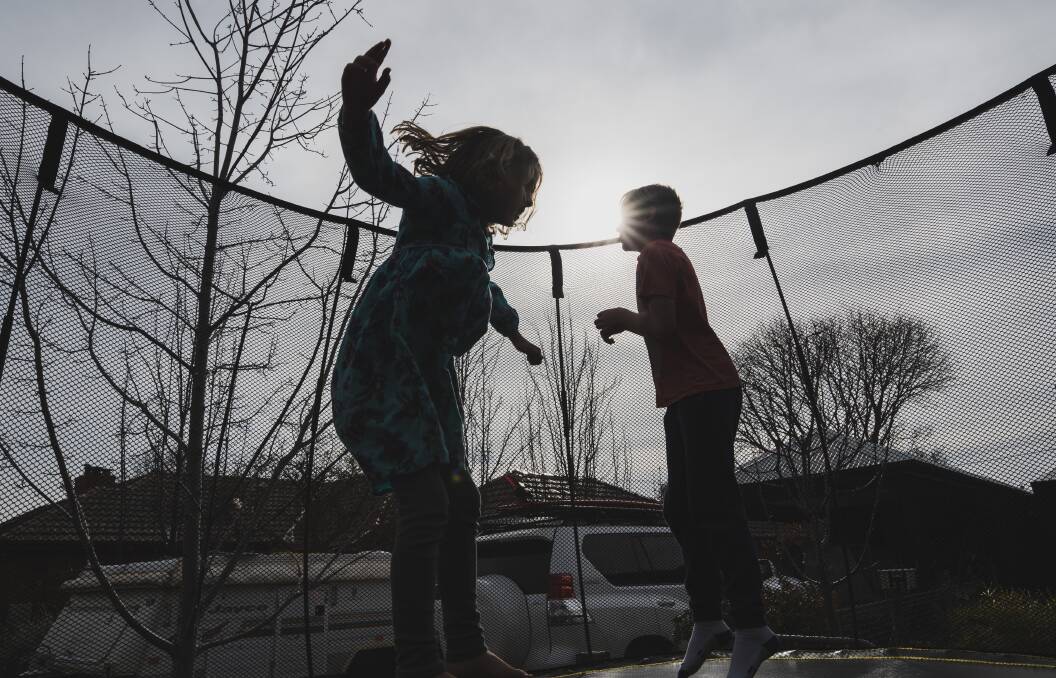 Sophie Watts, 8, and Louis Watts, 11, playing on their friends trampoline outside a home in Ainslie. Picture: Dion Georgopoulos