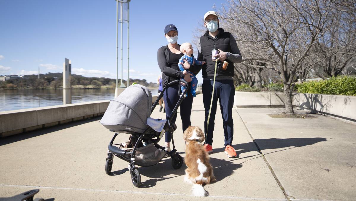 Lauren, Scott and Fletcher Dunn, 6 months, took their dog Donald for a walk around Lake Burley Griffin at the weekend as part of their one hour of exercise during the Covid lockdown. Families were taking the chance to enjoy the beautiful winter day. Picture: Dion Georgopoulos