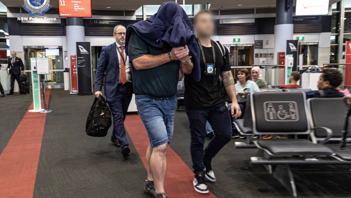 A 41-year-old Goulburn man is escorted through the airport as part of an extradition to NSW where he will face eight charges. Picture by NSW Police