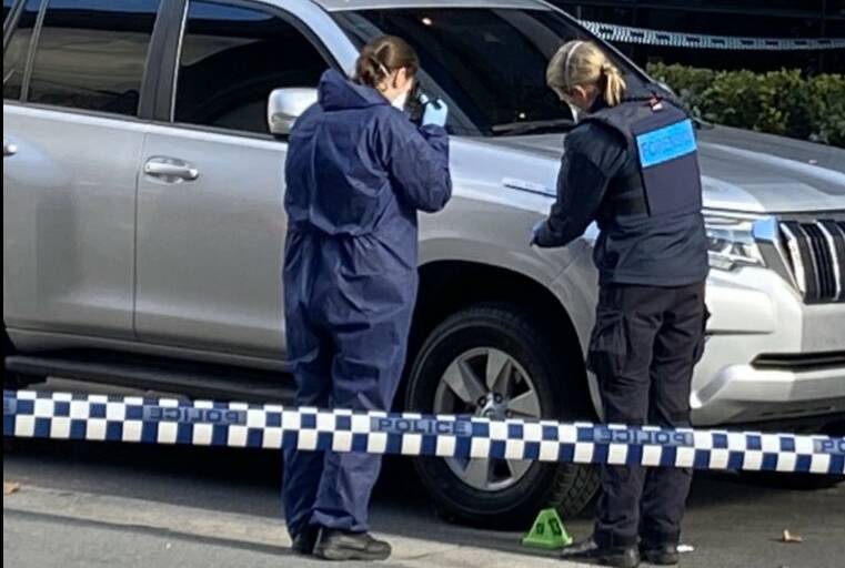 Police inspect what appears to be blood spatter on a car on Genge Street on Sunday. Picture: Sally Whyte