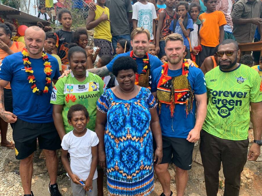 Former teammates of Kato Ottio visit his family in his PNG village. 