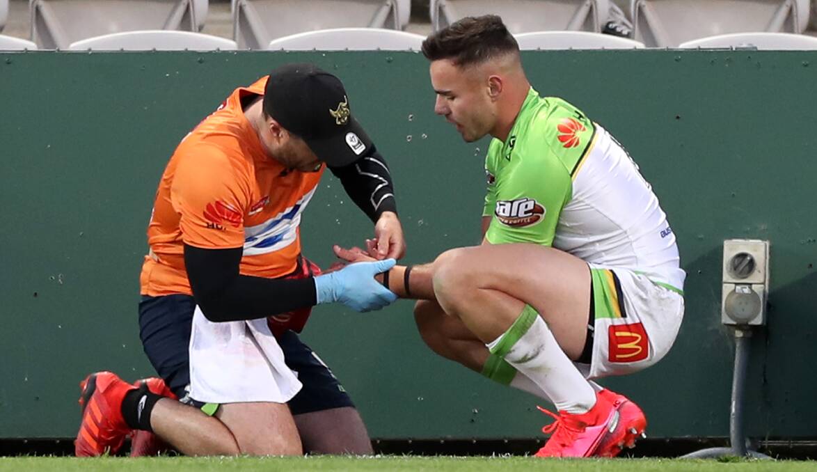 The trainer looks at Raiders young gun Harley Smith-Shields after he slid into the Kogarah Park fence. Picture: Getty Images
