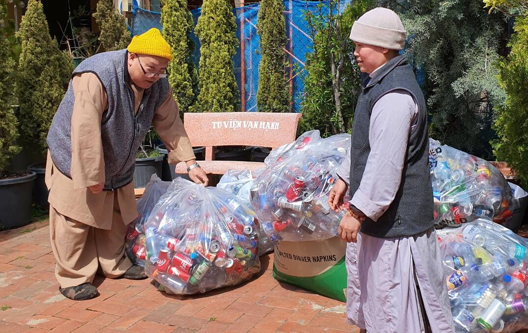 Recycling champions: Dao An and Thich Quang Bo from Canberra's Sakyamuni Buddhist Centre with bags of containers collected by their supporters.