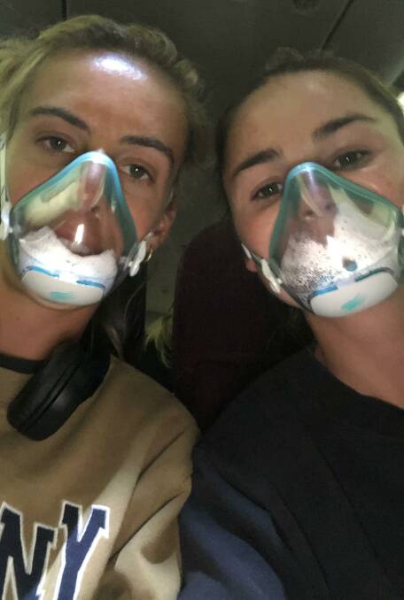 Commerford (right) wears a facemask on the flight home from Perth. Picture: Supplied