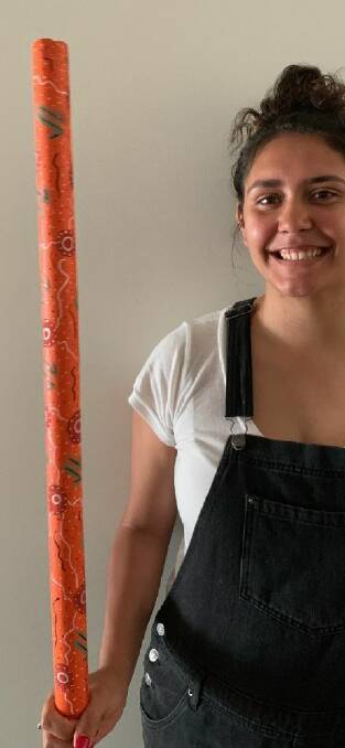 Local Indigenous artist Shaenice Allan with one of the painted stumps. Picture: Supplied.