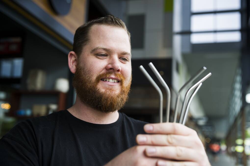Tristan Morthorpe holding the steel straws at the Atlas cafe in Gungahlin. Photo: Dion Georgopoulos