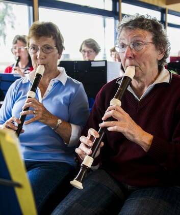 Judie Mackenna and Leslie Harland, members of the Recorder Orchestra, play in the ferry on Lake Burley Griffin yesterday . Photo: Rohan Thomson