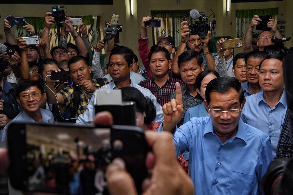 President of the Cambodian People’s Party Hun Sen raises his finger indicating he has voted. Photo: Kate Geraghty