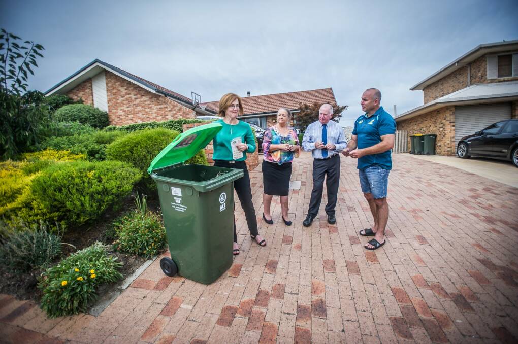 Calwell homeowner Stephen McDougall, right, receiving his green waste bin from a phalanx of ACT Labor politicians on Monday - from left, Meegan Fitzharris, Joy Burch and Mick Gentleman.  Photo: karleen minney