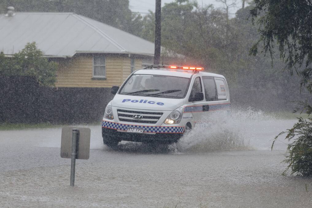 A police car drives through floodwater in south Townsville. Photo: Andrew Rankin - AAP