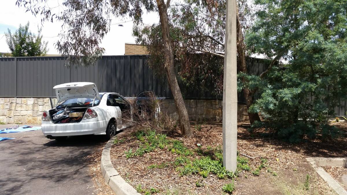 Detectives removed items, including a baseball bat, from a white car parked in a corner of a nearby carpark. Photo: Megan Gorrey