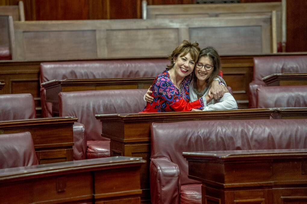 Kathy Lette sits in the seat once occupied by the first woman elected to the Senate, Dorothy Tangney. Pictured with her is Museum of Australian Democracy director Daryl  Karp. Photo: Karleen Minney