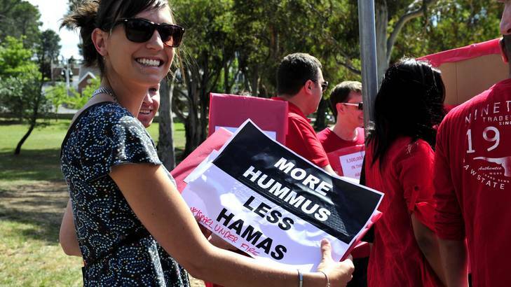 A protester holds a 'more hummus, less Hamas' sign. Photo: Jay Cronan
