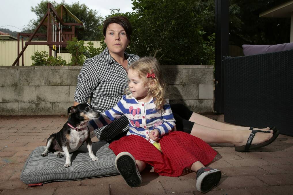 Renee Dean of Conder and daughter Chloe McGregor, 3, with their rescue dog Poppy. The family's two other dogs, Midge and Neo, were mauled to death by a neighbour's dogs in their own backyard in April, 2014. Photo: Jeffrey Chan