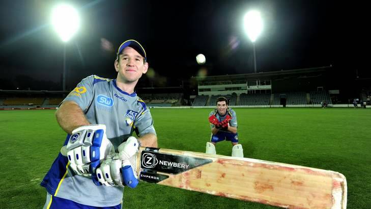 ACT Comets batsman Aaron Ayre and wicketkeeper Beau McClintock under the new lights at Manuka Oval. Photo: Melissa Adams