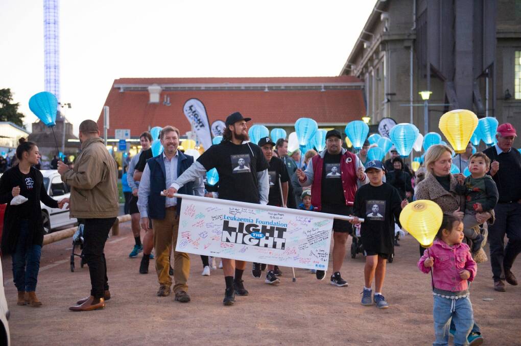 Jordan Smiler carries a banner with friends family and the 1000s of supporters of the Canberra Leukaemia Foundation Light the Night walk Photo Jay Cronan Photo: Jay Cronan