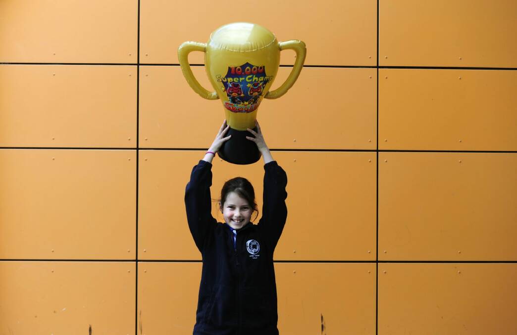 Abigail Mangin,12, celebrates the school's win with a trophy from Skoolbo.  Photo: Melissa Adams