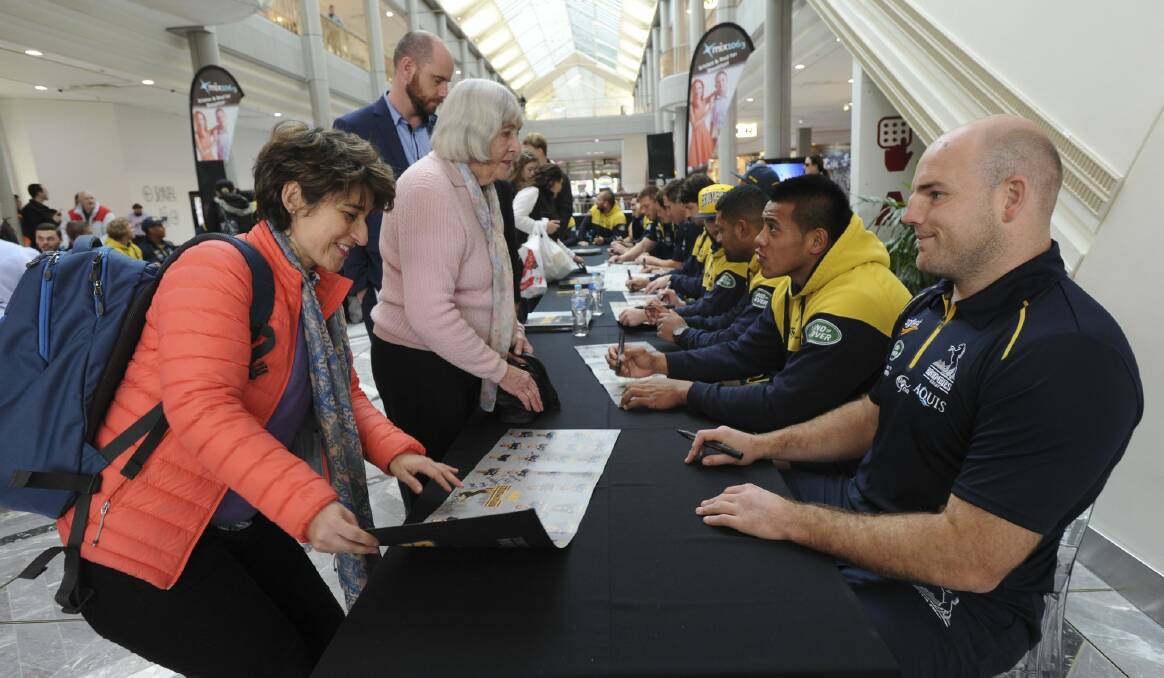 Rosario Lopez, a visiting professor from Colombia, gets an autograph from Brumbies captain Stephen Moore. Photo: Graham Tidy