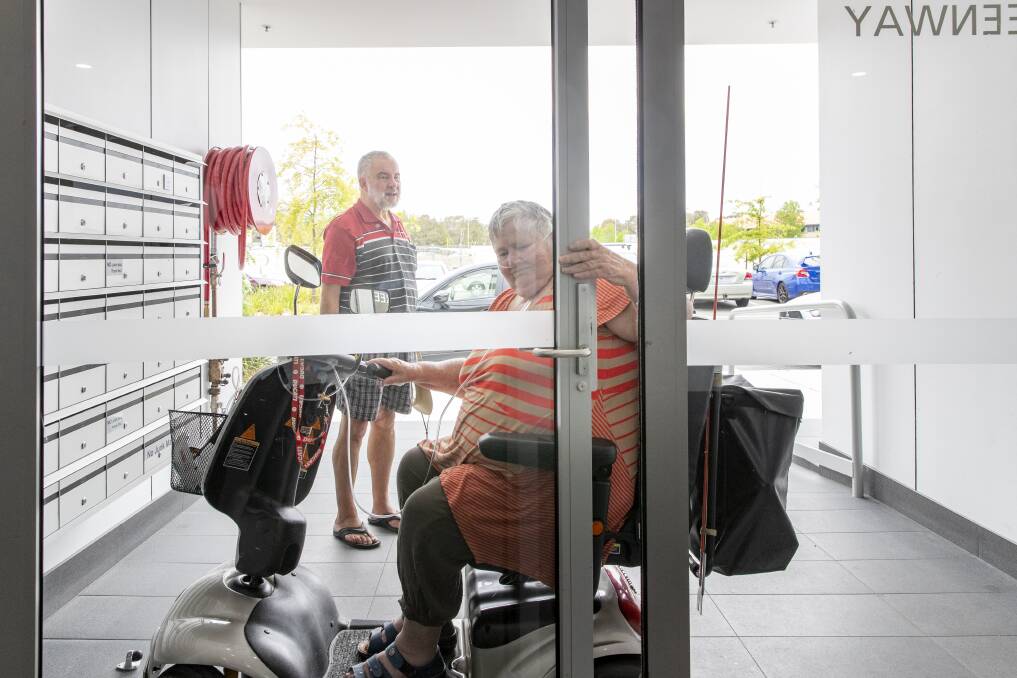 Pam Gaston and Peter Olley at their Tuggeranong apartment complex. Despite incorporating ramps for wheelchair access and disabled toilets, the lack of automatic doors makes it impossible for Pam to move around in her mobility scooter by herself.  Photo: Sitthixay Ditthavong