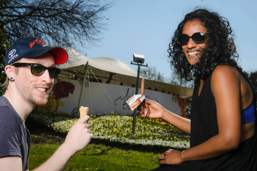 Jesse Armitstead and Shani Rajendra cool down with ice creams at Floriade. Photo: Sitthixay Ditthavong