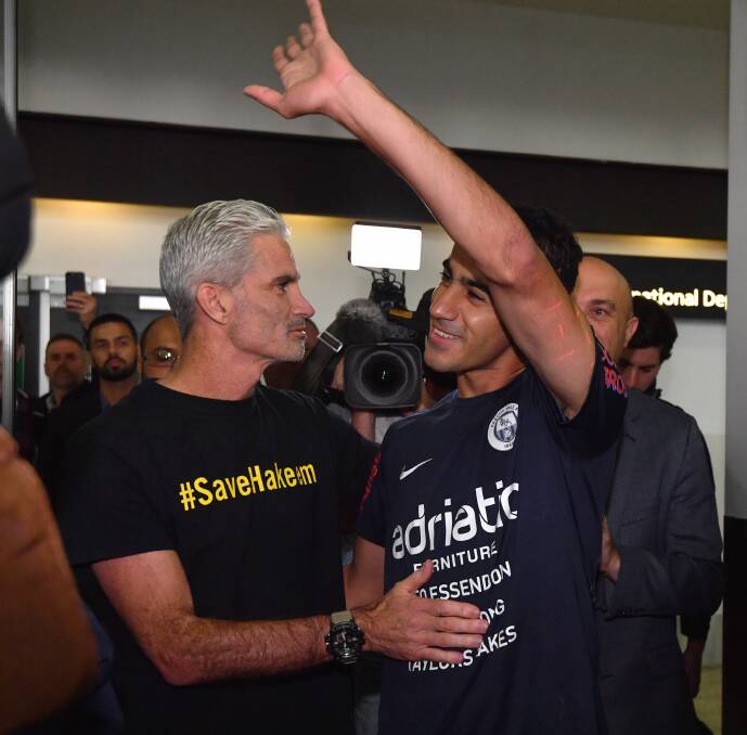 A jubilant Hakeem al-Araibi walks out of Melbourne Airport alongside former Socceroos captain Craig Foster. Photo: Joe Armao