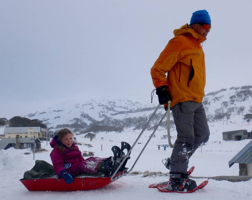 Pete Cocker of K7 Adventures gives Emily a ride back into Perisher on a sled. Photo: Tim the Yowie Man
