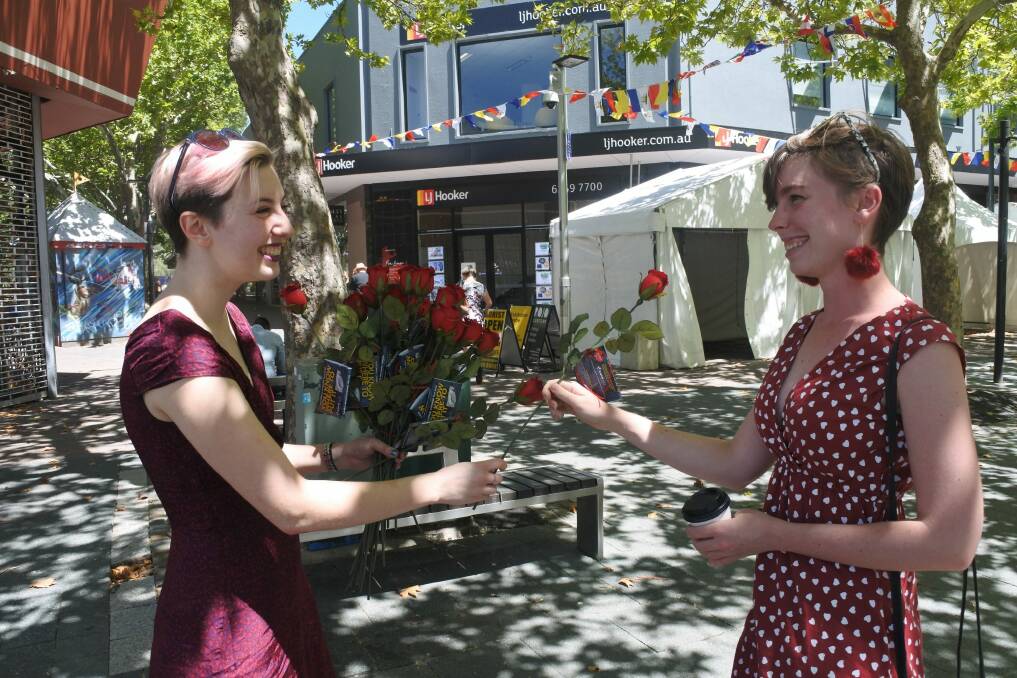 Pi Lee from Sexual Health and Family Planning gives a rose to Emily Bugden in Civic on Valentine's Day. Photo: Megan Doherty