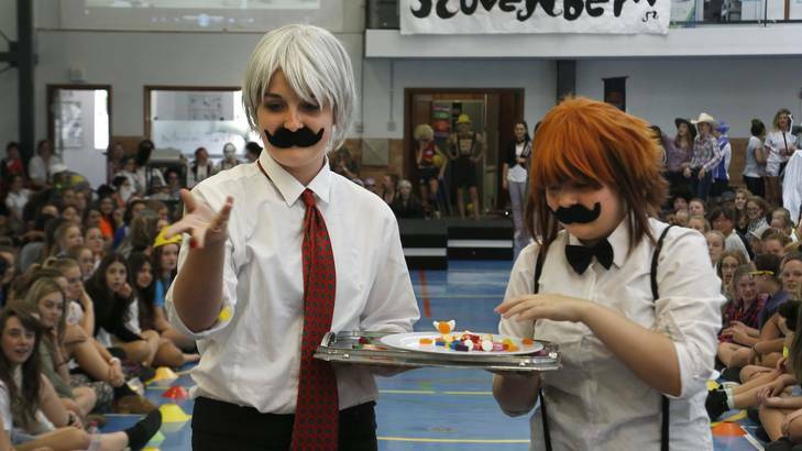 Merici College students Sarah Beaver and Bree Hall offer some lollies to the judges during the Movember Fashion Parade. Photo: Jeffrey Chan