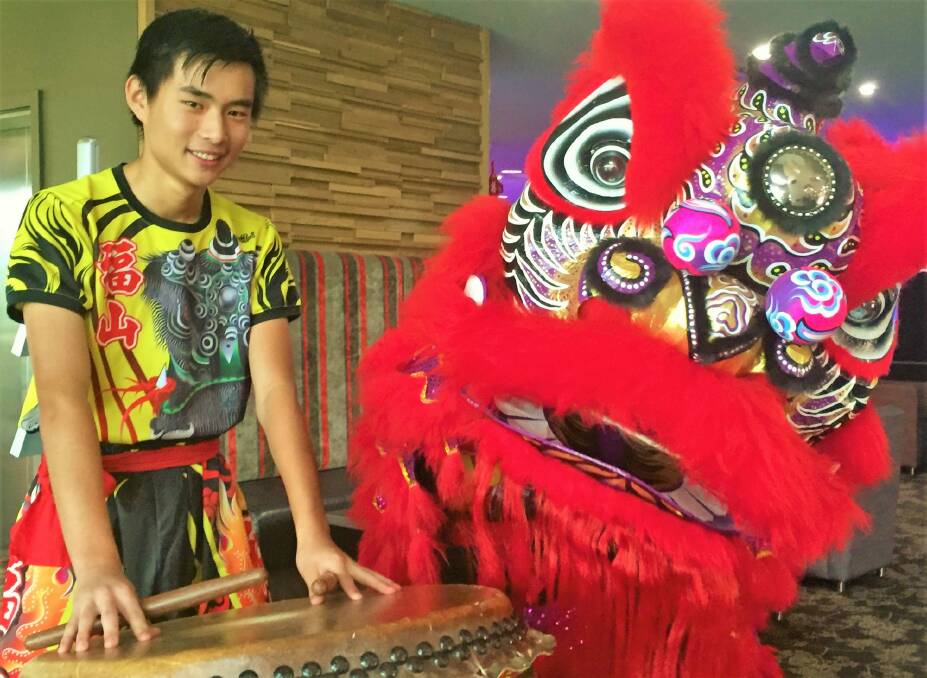 Drummer Andy Zhang, left, poses next to group founder David Wong  inside his lion dance costume. Photo: Steven Trask