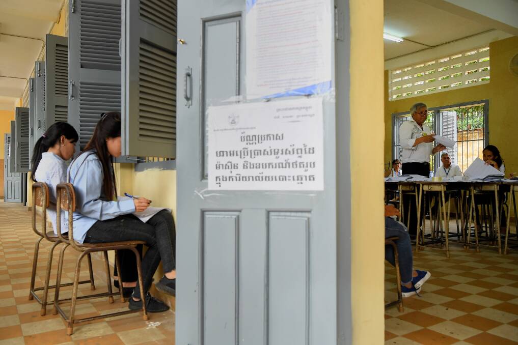 An election official counts the votes from the Cambodian election as two women independently record the count. Photo: Kate Geraghty
