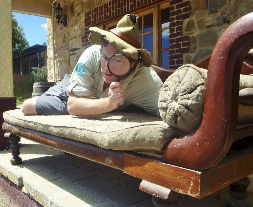 Item of interest: On the verandah of Collector's Bushranger Hotel, Tim the Yowie Man inspects the antique couch on which Constable Samuel Nelson's body was supposedly placed after he was killed by a bushranger on January 26, 1865. Photo: Gary Poile