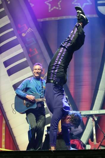 Lachy Wiggle [Lachlan Gillespie] singing about Canberra while doing a hand stand during the Ready Steady Wiggle concert at the AIS Arena. Photo: Jeffrey Chan