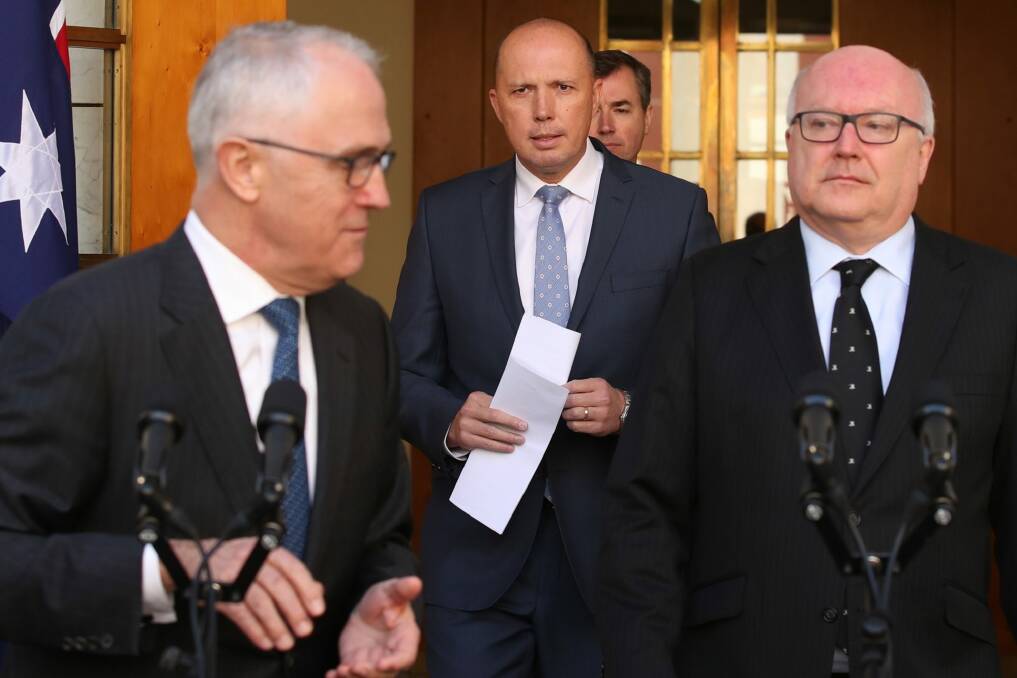 George Brandis with Peter Dutton, centre, and Malcolm Turnbull  announcing the new Home Affairs ministry in July. Photo: Andrew Meares