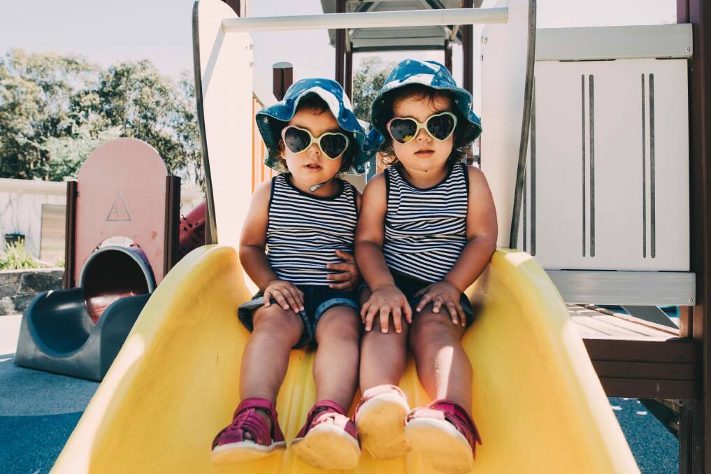 Two-year-old twins Isabella and Madeleine Bodell stay sun smart at Boundless Playground. Photo: Jamila Toderas