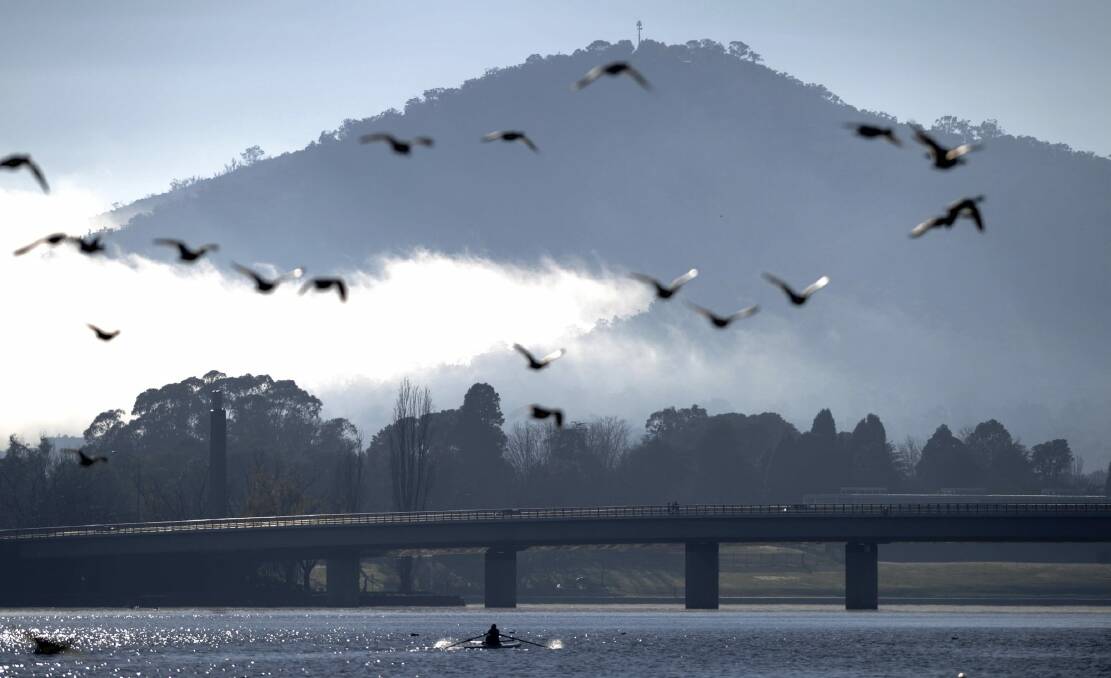 A nippy start to the day with users of Lake Burley Griffin taking in the glorious scene. Photo: Graham Tidy