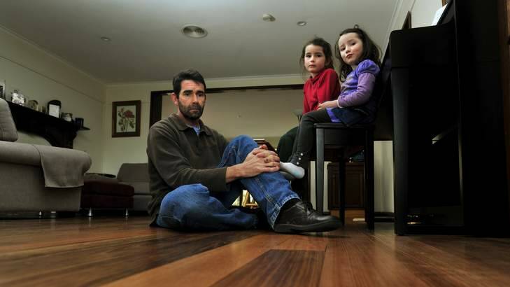 Mark Harradine and his daughters Catie, 6, and Elise, 4, live in one of Canberra's Mr Fluffy houses that was insulated with loose asbestos fill in the 1970s. Photo: Melissa Adams