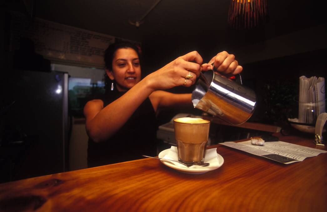 A barista displaying for skill at a Brisbane cafe. Photo: Doug Steley/Alamy