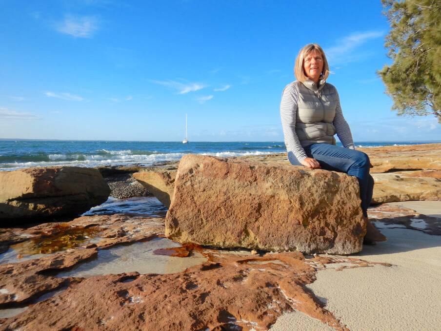 Jenny Robertson sits on an old sandstone block, a remnant of the South Huskisson wharf at the end of the Wool Road. Photo: Tim the Yowie Man