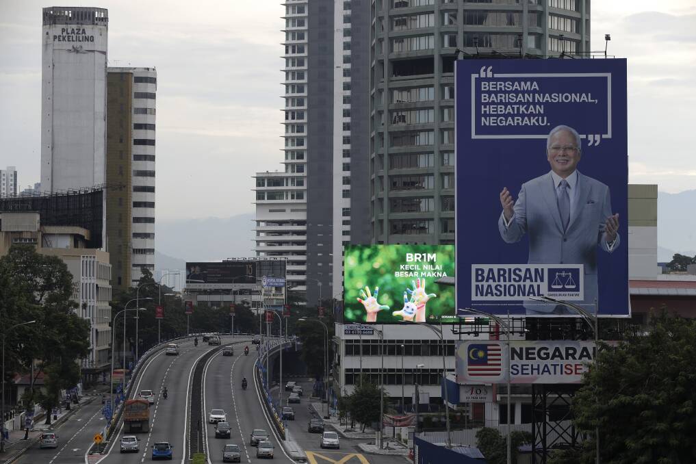 Fallen idol: A giant campaign billboard of defeated incumbent Najib Razak looms over the highways of Kuala Lumpur. Photo: AP