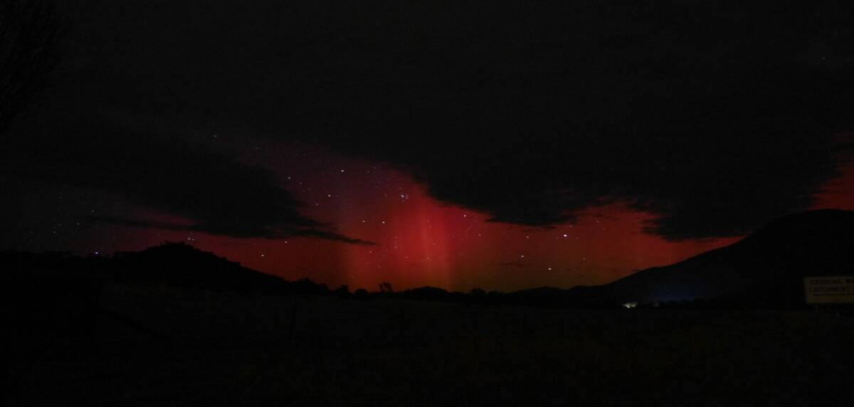 The pink-red glow of the Aurora Australis above Mt Tennent on Tuesday morning. Photo: Ian Williams