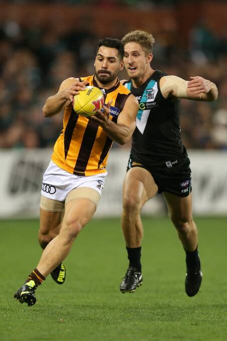 Paul Puopolo of the Hawks competes with Hamish Hartlett. Photo: AFL Media/Getty Images