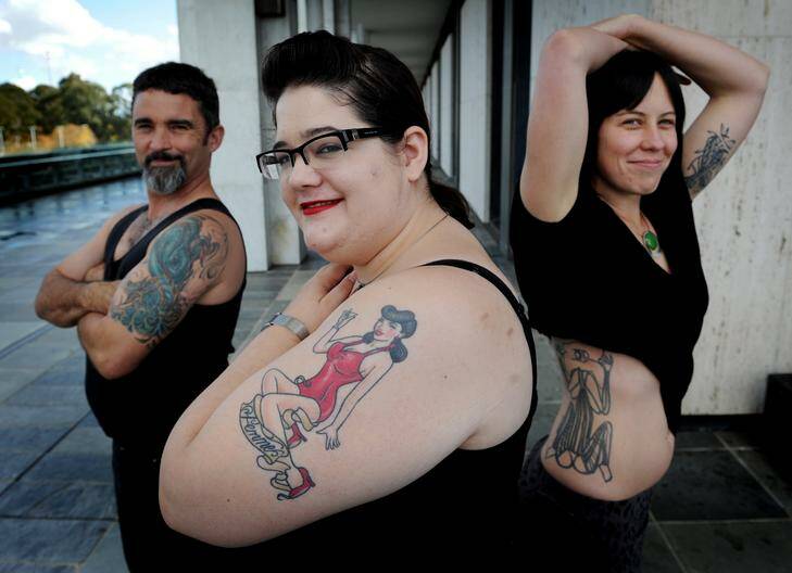 NLA staff with their tattoos as part of body art book to be launched next year. (L to R) Mike Bailey, Marion Kruger and Jodie Harris. Photo: Colleen Petch