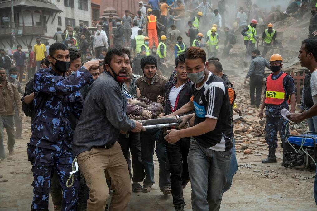Emergency rescue workers carry a victim on a stretcher after Dharara tower collapsed in Kathmandu, Nepal.  Photo: Getty Images