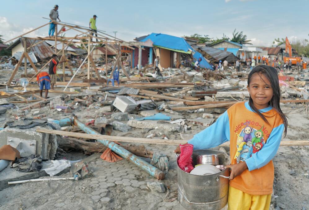 Ten-year-old Suci Rahmadi at Mamboro beach with pots and pans  she has collected from the debris.  Photo: Amilia Rosa