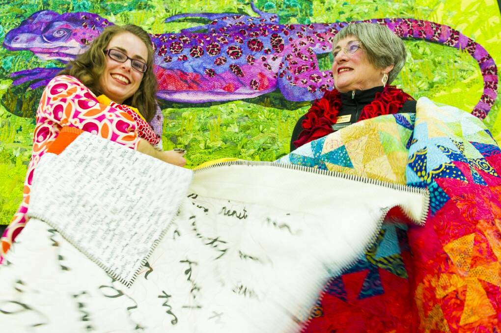 Canberra Quilters' member Gemma Jackson and president Helen Rose get ready for the quilt show. Photo: Jay Cronan