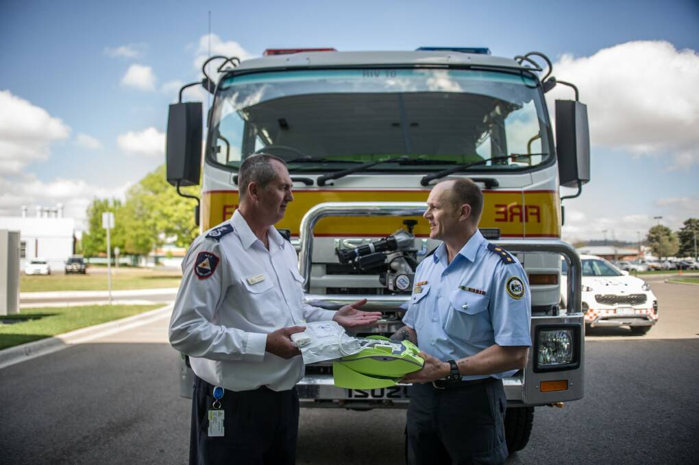 ACT Rural fire service Chief Officer Joe Murphy SES senior manager Operations and governance Rob Thompson inspect the automatic external defibrillator.  Photo: Karleen Minney